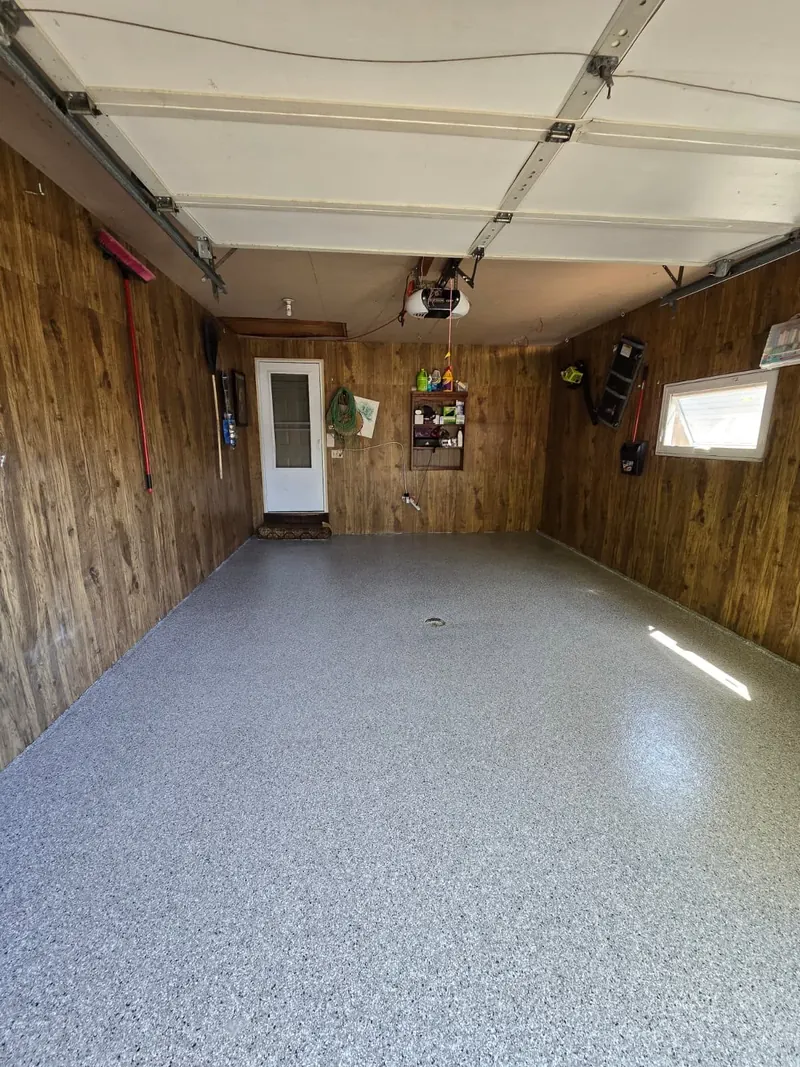 Feather Gray flake garage floor with polyaspartic top coat, wood-paneled walls and drain, Allouez, WI