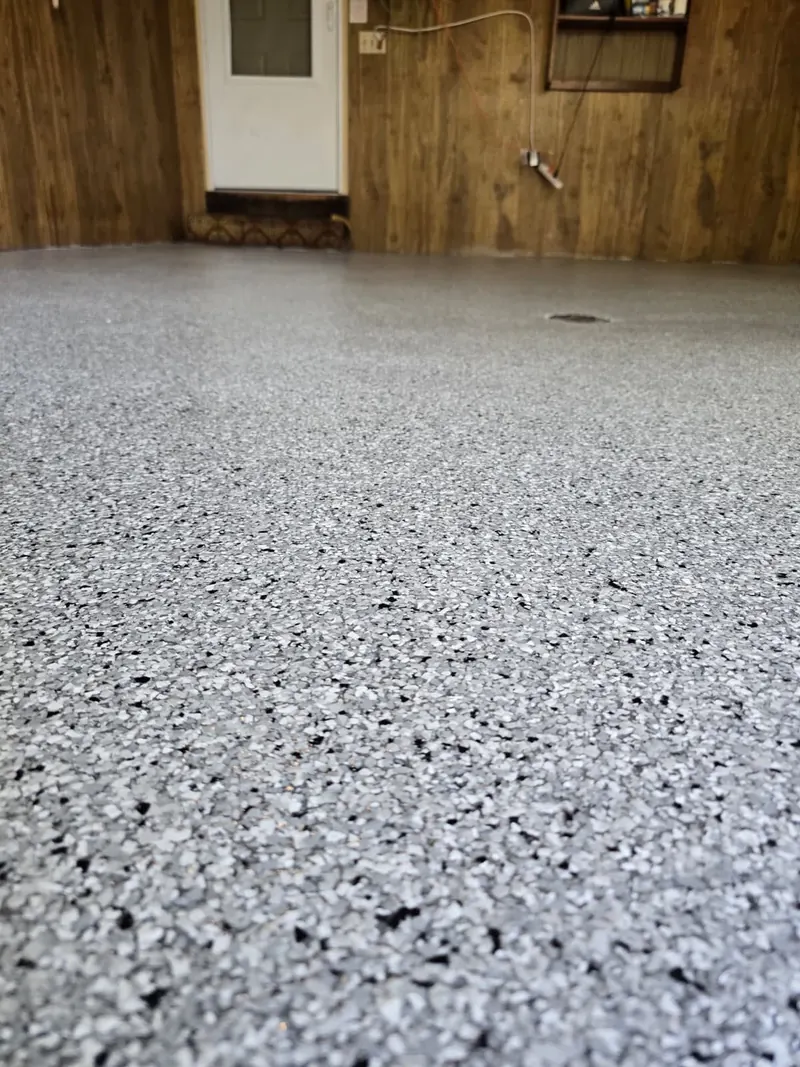 Close-up of Feather Gray flake texture near the entry door step in an Allouez, WI garage