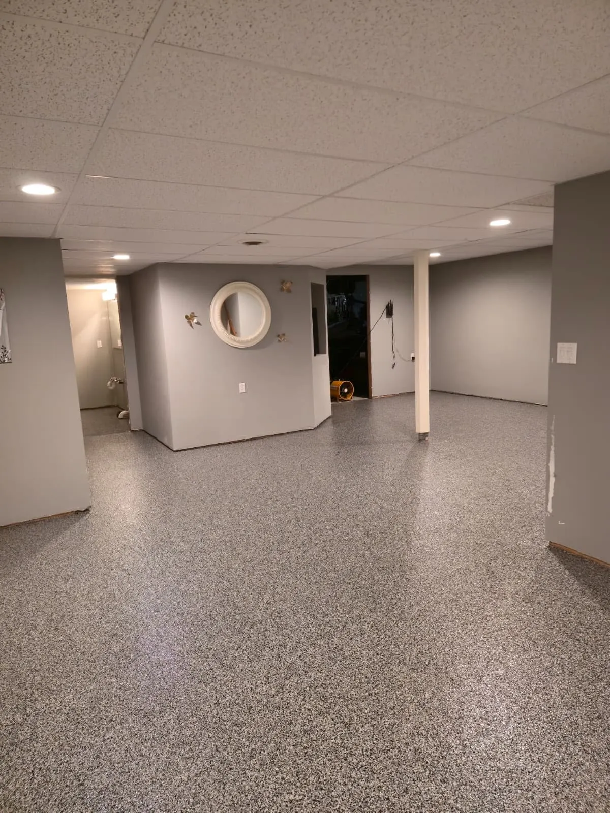 Open basement living area with decorative flake epoxy coating
