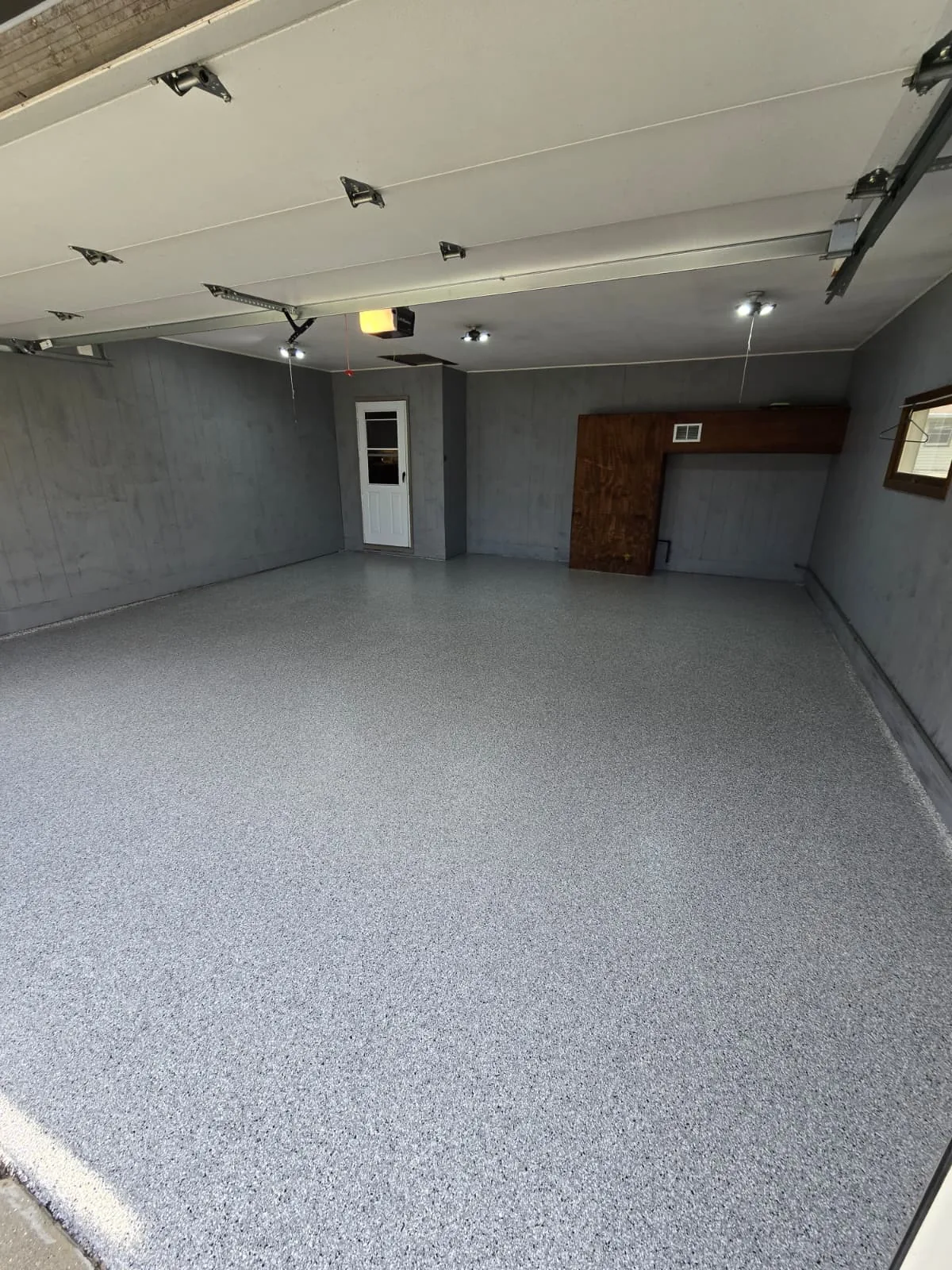 Light grey flake epoxy garage with overhead lighting