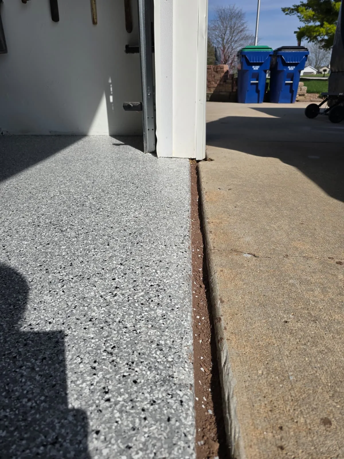 Crisp edge of flake epoxy at garage door threshold