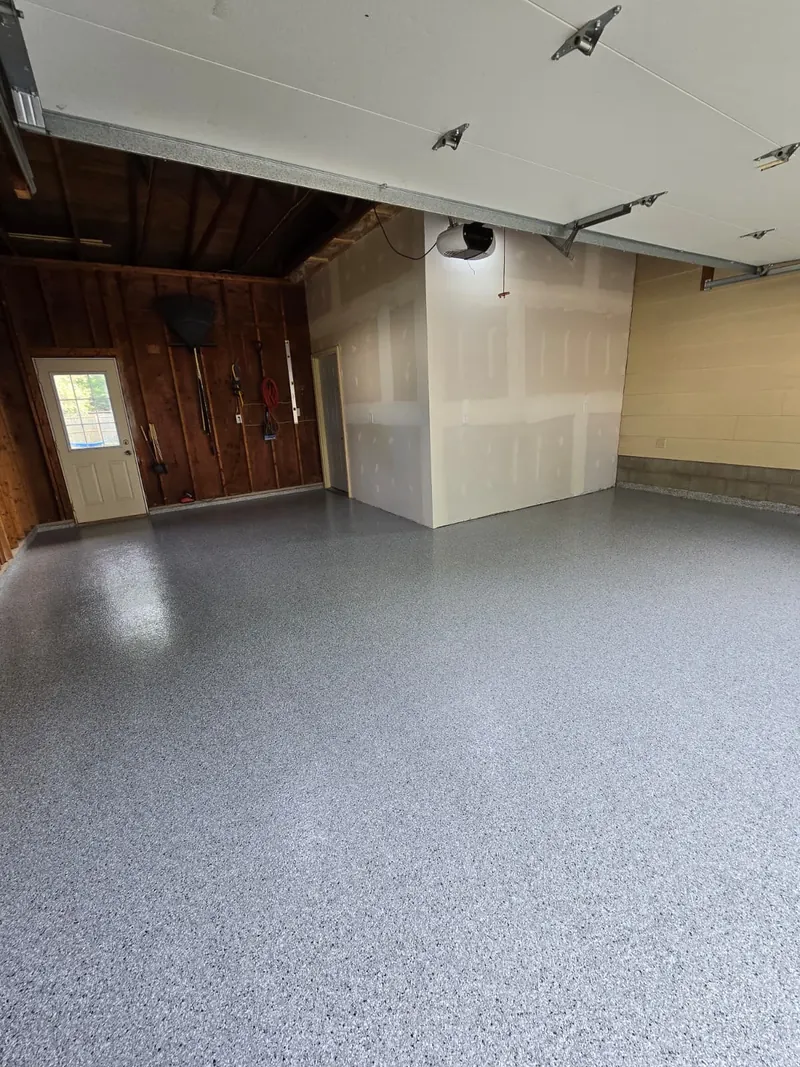 Glossy gray flake coating across a 2-car garage with polyaspartic top coat in Marinette, WI
