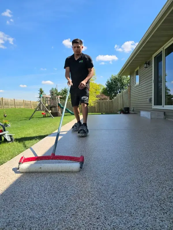 Applying a polyaspartic top coat to a flake patio deck in De Pere, WI